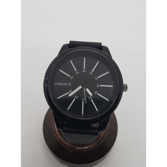 Caquo men's watch. Large black face. Black adjustable band. White hands on face.